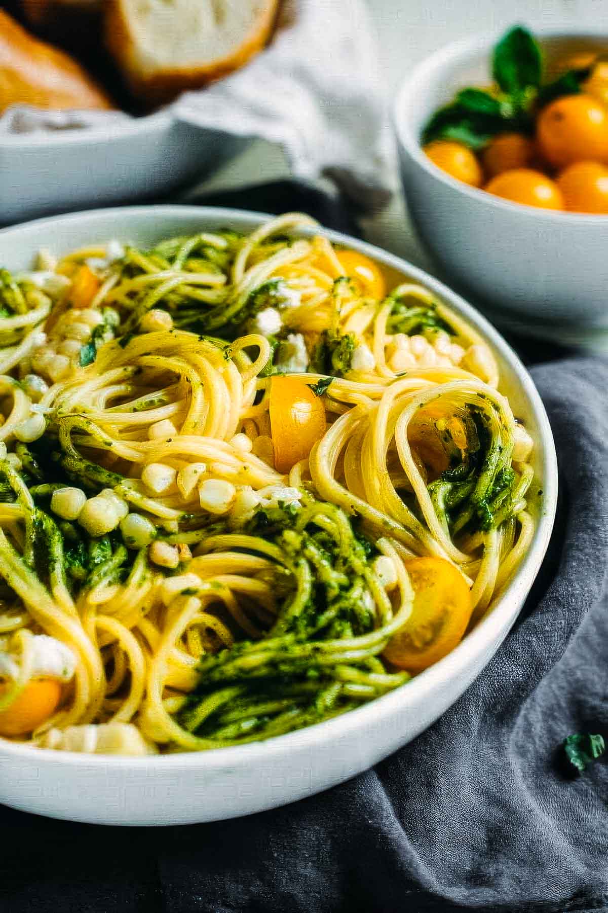 Summer Pasta Salad with Avocado Pesto summer pasta salad with avocado pesto in a white bowl with swirls of spaghetti noodles